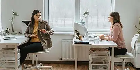 Zwei Personen im Büro unterhalten sich