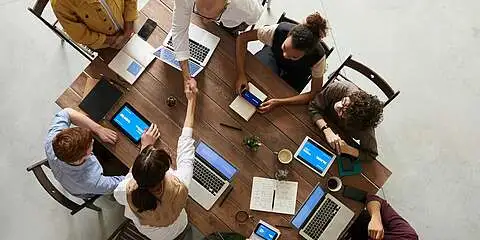 Menschen arbeiten an einem Tisch zusammen